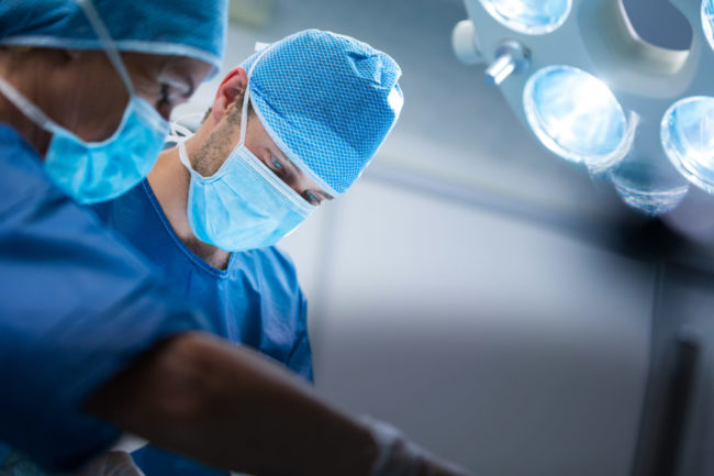 Surgeons performing operation in operation room